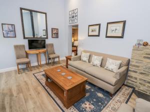 een woonkamer met een bank en een salontafel bij Lily Stables in Carterton