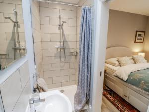 een badkamer met douche en wastafel en een bed bij Lily Stables in Carterton +19 foto's