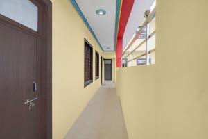 an empty hallway in a school with a door at Hotel O Shubh Inn in Jhānsi +27 photos