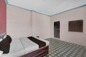 a bedroom with a bed and a television in it at Hotel O Shubh Inn in Jhānsi