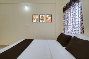 a bed in a room with three pictures on the wall at Hotel O Kalpatharu Boarding and Lodging in Tyāmagondal