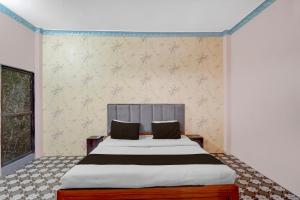 a bedroom with a large bed and a window at Hotel O Shubh Inn in Jhānsi