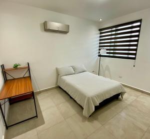 a bedroom with a bed and a table and a window at Cozy Room in Monterrey +4 photos