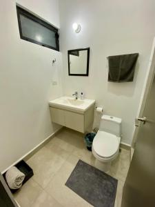 a bathroom with a white toilet and a sink at Cozy Room in Monterrey