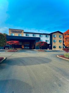 a parking lot in front of a large building at Creekside Hotel & Suites in Canyonville