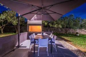 a table and chairs under an umbrella on a patio at Holiday Home in Ždrelac with Seaview, Terrace, Air condition, WIFI (4652-1) in Ždrelac