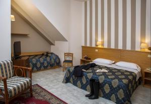 una camera d'albergo con due letti e una sedia di Hotel Redebora a Torregrotta