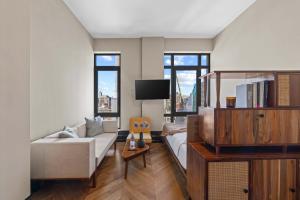 een woonkamer met een bank en een tv bij Freeman 901 by Rove Studio with Shared Amenities in New York