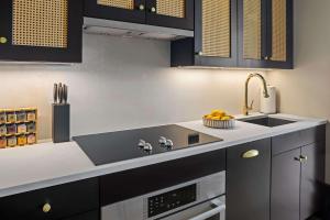 een keuken met zwarte kasten en een spoelbak bij Freeman 901 by Rove Studio with Shared Amenities in New York +22 foto's