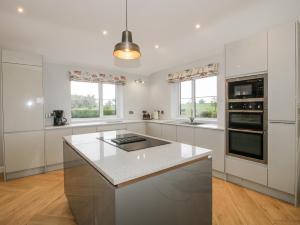 a kitchen with white cabinets and a white counter top at Garden Cottage in Petton +15 photos