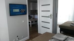 a living room with a door with a television on it at Horyzont Międzyzdroje in Międzyzdroje