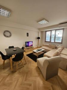 a living room with a couch and a table at Lovely square apartment Purple Velvet 43 Macedonia Stree in Skopje