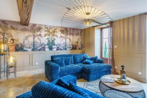 a living room with blue couches and a table at Hôtel Le Clos des Arts in Gevrey-Chambertin