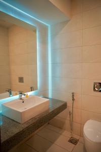 a bathroom with a white sink and a toilet at 2 BD Designer Apt - Islamabad and Mountain Views in Islamabad