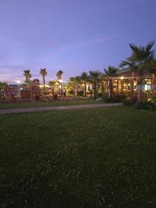 a park with palm trees and a playground at night at Rozana's sweet home, San Pietro Resort, Gjiri i Lalzit in Lalzit Bay