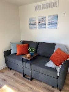 un soggiorno con divano grigio e cuscini arancioni di Cozy Cottage - Lakeview a Marmaros