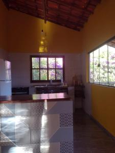 a kitchen with a counter and two windows at Pousada Pássaros da Manhã in Vale do Capao
