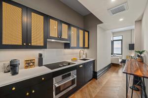 een keuken met zwarte kasten en witte aanrechtbladen bij Freeman 1201 by Rove Studio with Shared Amenities in New York