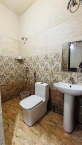 un baño con inodoro y lavabo en Hotel Devraj, en Rishīkesh