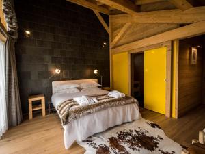 - une chambre avec un grand lit et un mur jaune dans l'établissement Chalet au pied du Pleney avec Jacuzzi, Sauna et Wifi - FR-1-524-139, à Morzine