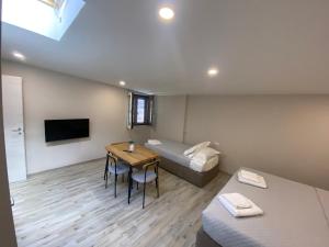 een kamer met een bed en een tafel en een bed en een kamer met bij Santa Caterina Apartament in Poggibonsi