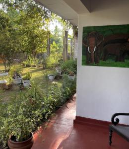 a painting of an elephant on a wall in a garden at Villa Claudia Nimal's kitchen in Ahangama