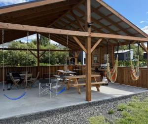 a large wooden pavilion with picnic tables and swings at Hebergement du grenier 2 0 in Notre-Dame-des-Monts