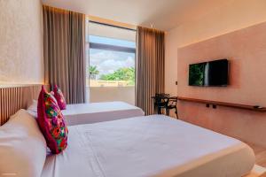 una camera d'albergo con due letti e una finestra di Casa Oneiro Hotel Boutique & Suites a Mérida