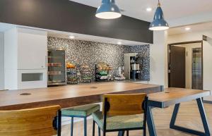 eine Küche mit einer Theke mit 2 Stühlen und einem Tisch in der Unterkunft Extended Stay America Premier Suites - Nashville - Smyrna in Smyrna