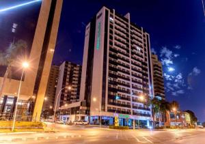 a tall building with a sign on it at night at Flat particular Vision Executive in Brasília