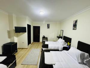 a room with three beds and a flat screen tv at Hany pyramids view in Cairo