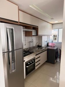 eine Küche mit weißen Schränken und einem Edelstahlkühlschrank in der Unterkunft Seu Refúgio em São Luís MA in São Luís