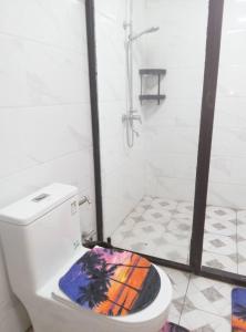 a bathroom with a shower and a toilet with a colorful seat at Samoa FINAU 685 Accomodations in Vaitele +1 photo