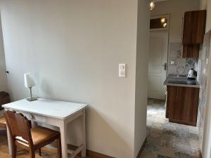 Una cocina con una pequeña mesa blanca y un mostrador. en Vasso, en Nancy