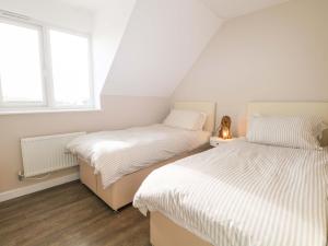 two beds in a room with two windows at Harbour Way in Shoreham-by-Sea