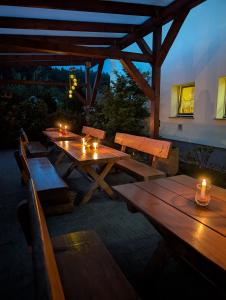 a wooden picnic table with candles on a patio at Pension zum Reiterhof, 3-Bettzimmer in Schmogrow