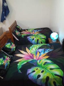a bedroom with two beds with flowers on them at Samoa FINAU 685 Accomodations in Vaitele