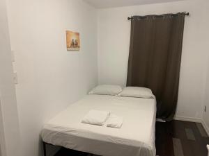 een kleine slaapkamer met een bed met 2 kussens erop bij Napaeno's Place - Home Away from Home in Kingston