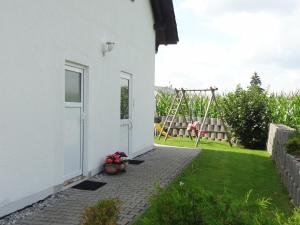 une maison blanche avec une cour et une balançoire dans l'établissement Ferienwohnung Ebersbach, à Guntzbourg