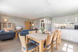 a kitchen and living room with a wooden table and chairs at Inselhuus Fehmarn 2 in Petersdorf auf Fehmarn