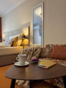 a living room with a coffee table and a bed at Hotel Garni Expo in Banská Bystrica