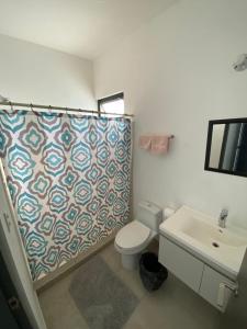 een badkamer met een toilet, een wastafel en een douchegordijn bij Habitación cómoda y agradable in Monterrey
