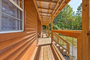 eine umlaufende Veranda eines Holzhauses mit einem Fenster in der Unterkunft Hot Tub - Sit and Stay Cabin in Red River Gorge KY in High Falls