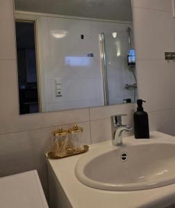 a bathroom sink with a mirror and a soap dispenser on it at Tromsdalen Studio 2 - FREE Parking, Views & Quiet Area in Trondalen +6 photos