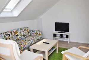 a living room with a couch and a tv at Mala in Landkirchen