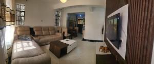 a living room with a couch and a flat screen tv at Kim's Executive Two-Bedroomed Apartment in Nakuru