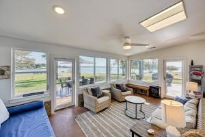 ein Wohnzimmer mit Sofa, Stühlen und Fenstern in der Unterkunft Modern, Spacious! Lake Buchanan Retreat with Hot Tub in Tow