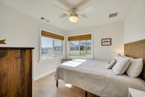 Schlafzimmer mit einem Bett, einem Deckenventilator und Fenstern in der Unterkunft Modern, Spacious! Lake Buchanan Retreat with Hot Tub in Tow