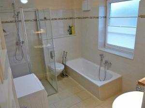 a bathroom with a shower and a tub and a toilet at Haus Wellenkamp in Burg auf Fehmarn +7 photos