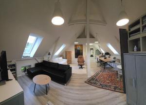 un soggiorno con un divano nero e un tavolo di Auszeit im Backhuus a Teschendorf